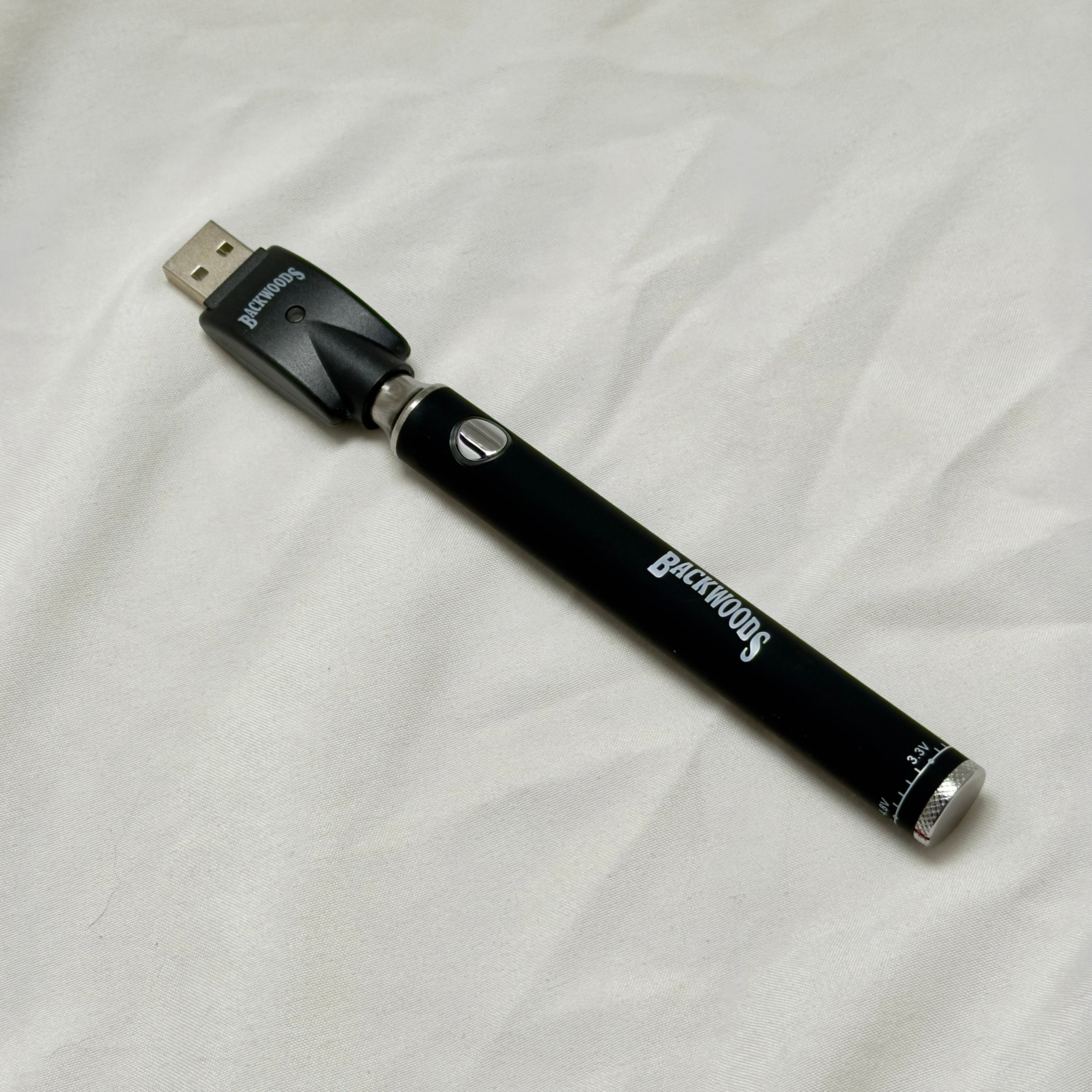 Black electronic device with USB connector on a white fabric background