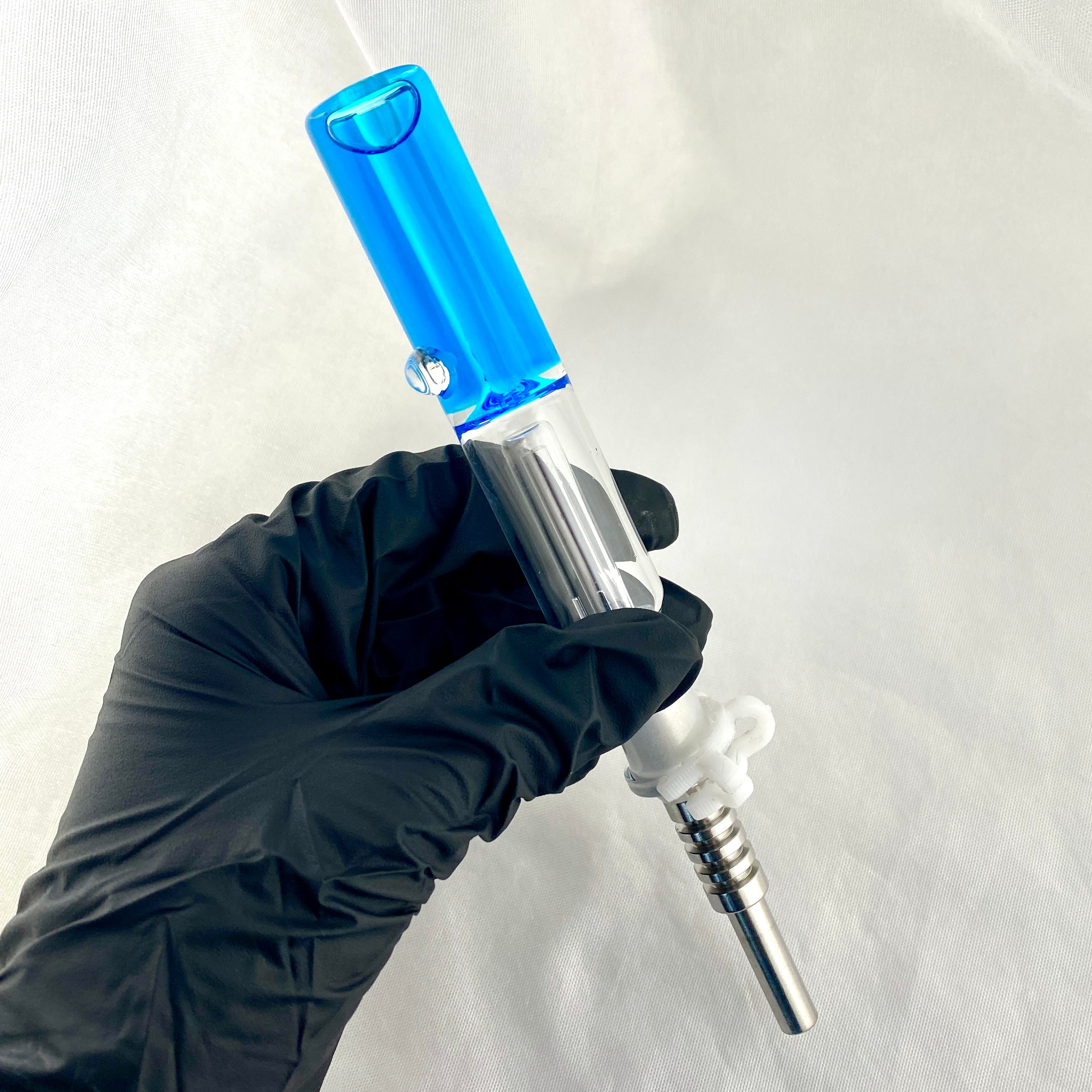 Hand in black glove holding a blue and silver syringe against a white background