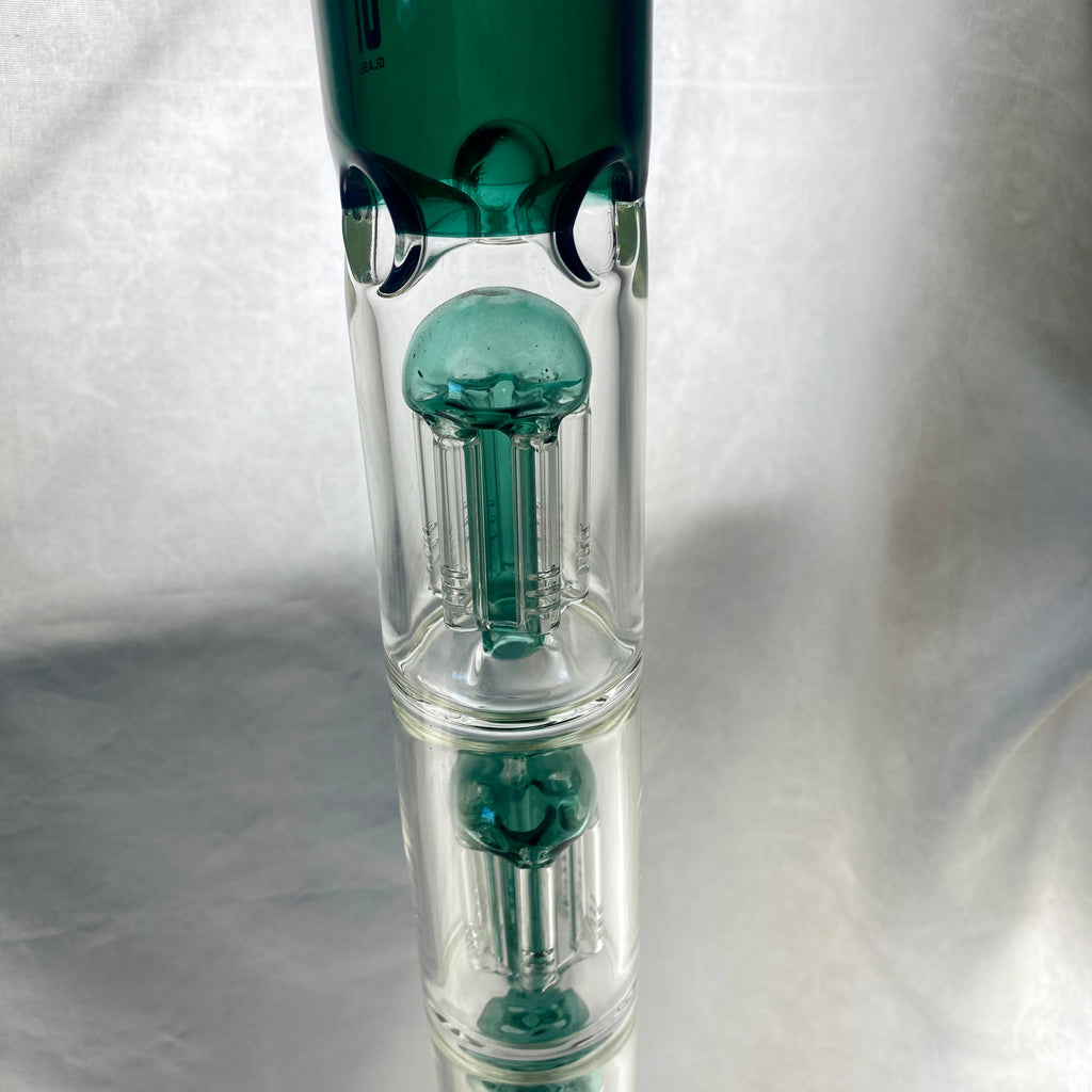 Glass smoking device with green and clear components on a white background