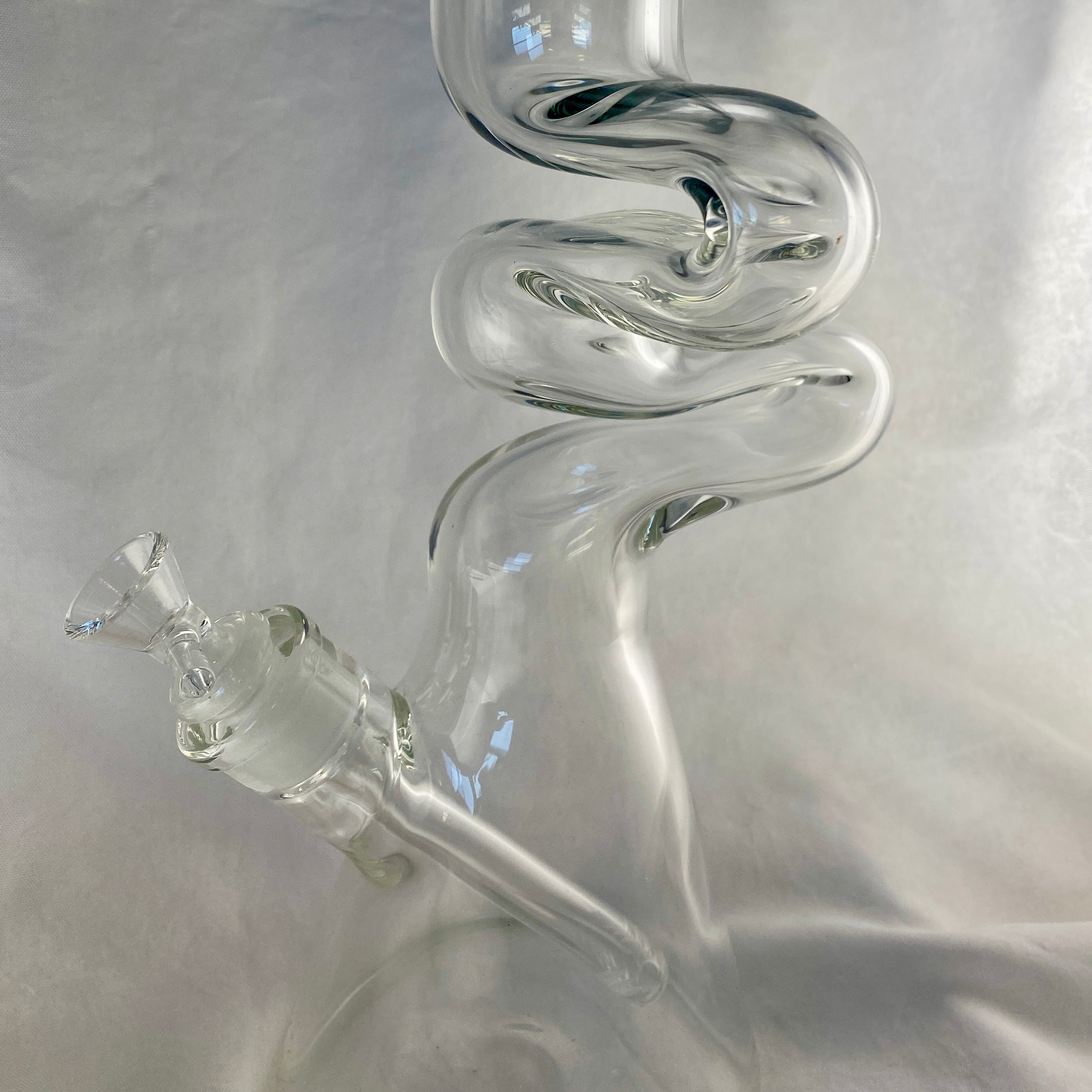 Clear glass smoking device with spiral design on a gray background