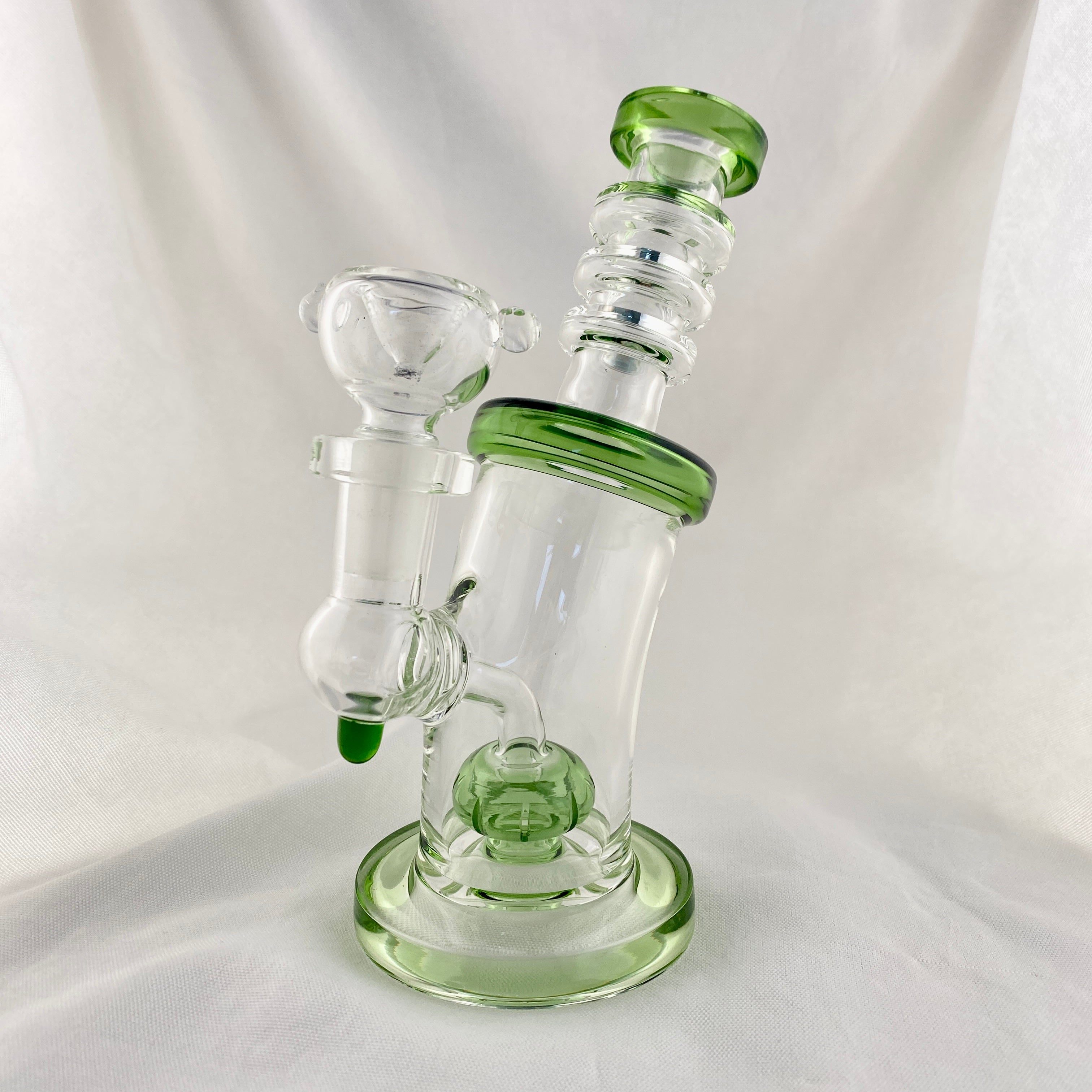 Glass water pipe with green accents on a white background