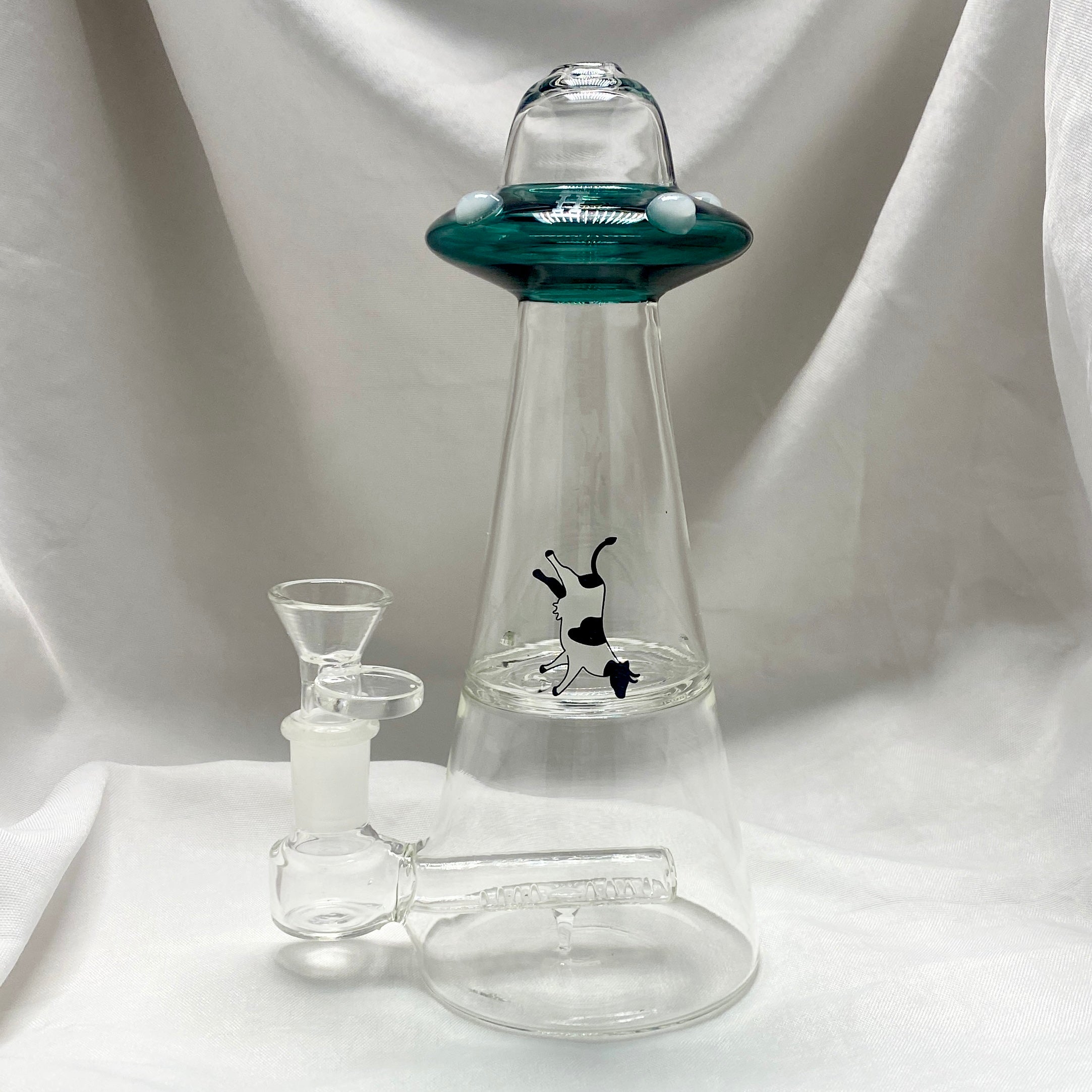 Clear glass smoking apparatus with a green top on a white background