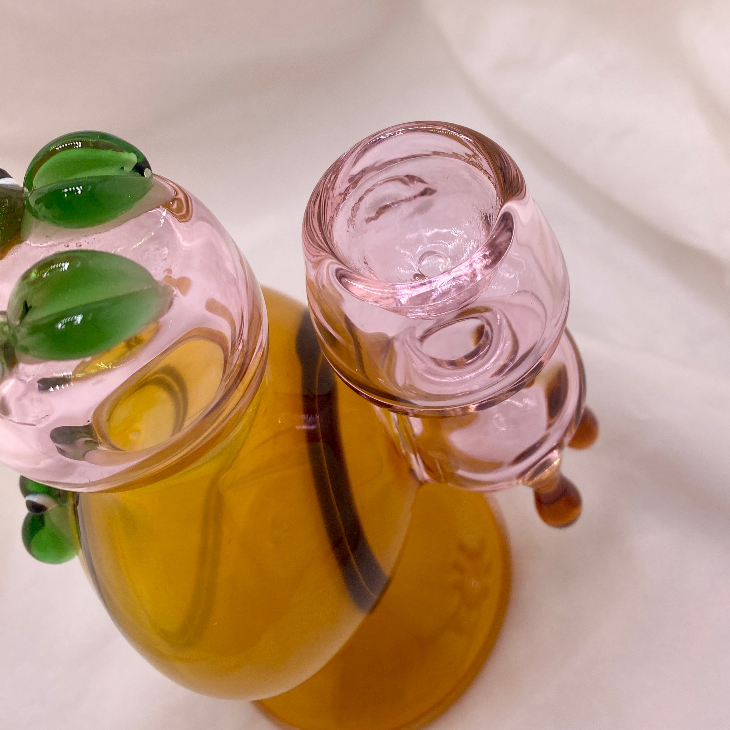 Glass smoking accessory with green accents on a white background