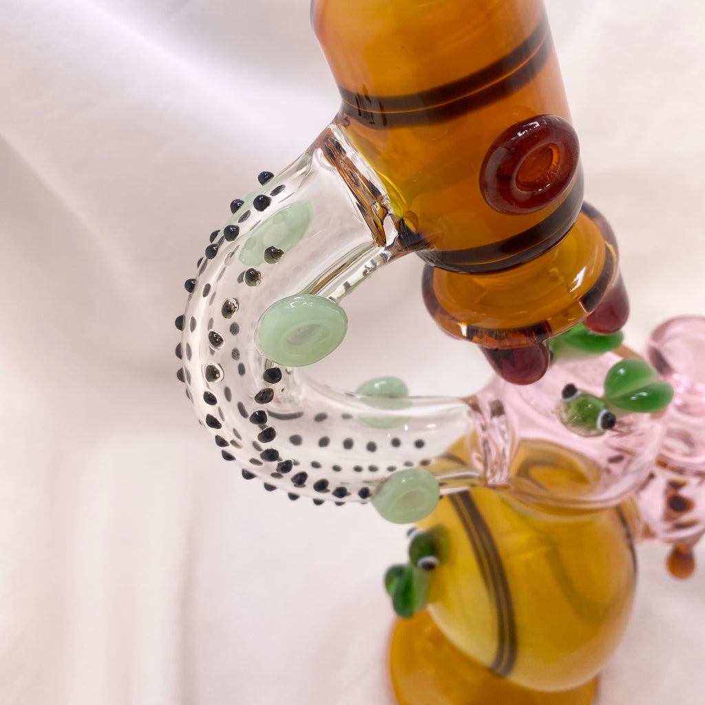 Close-up of a glass smoking accessory with colorful design on a white background