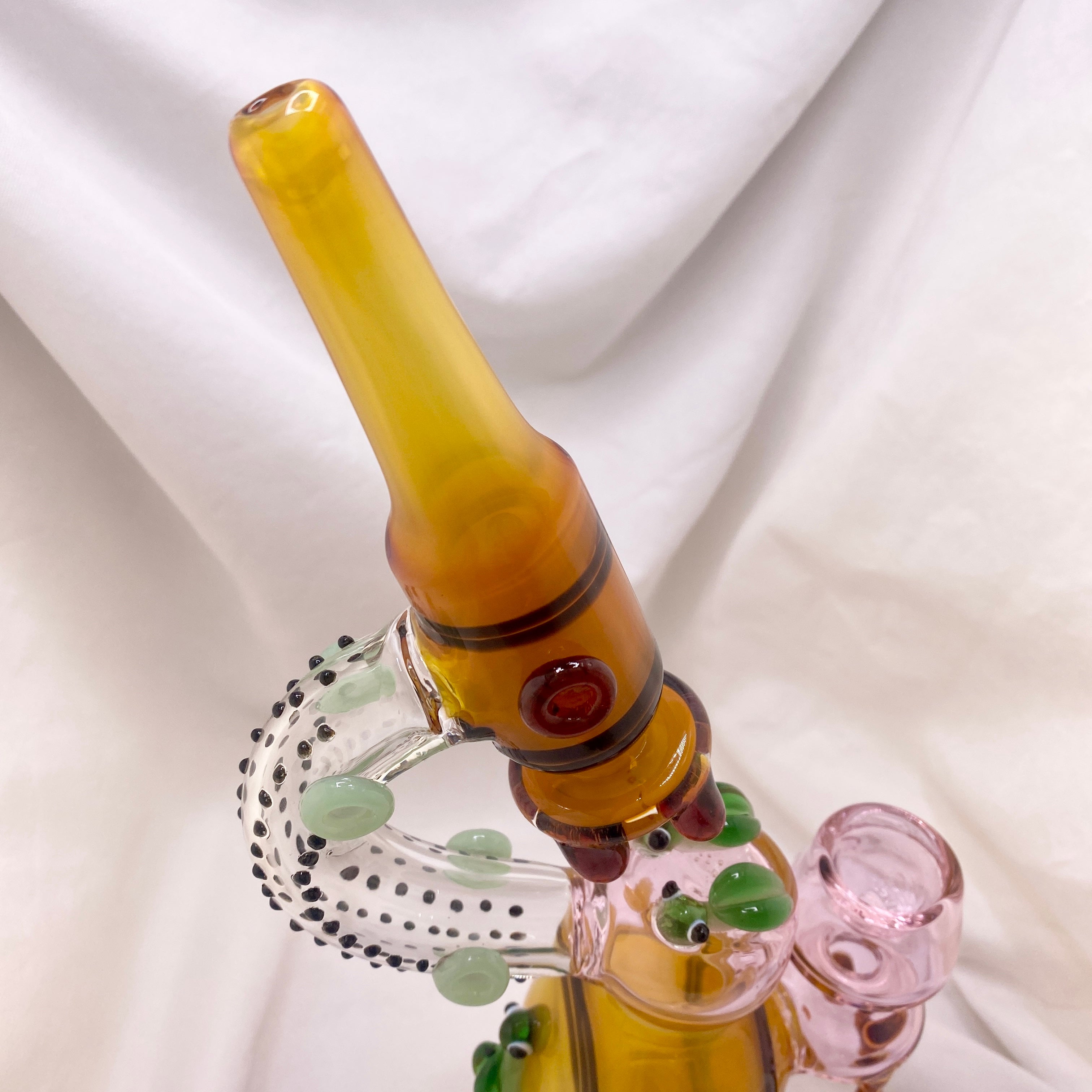 Glass smoking accessory with a yellowish-brown pipe on a white background