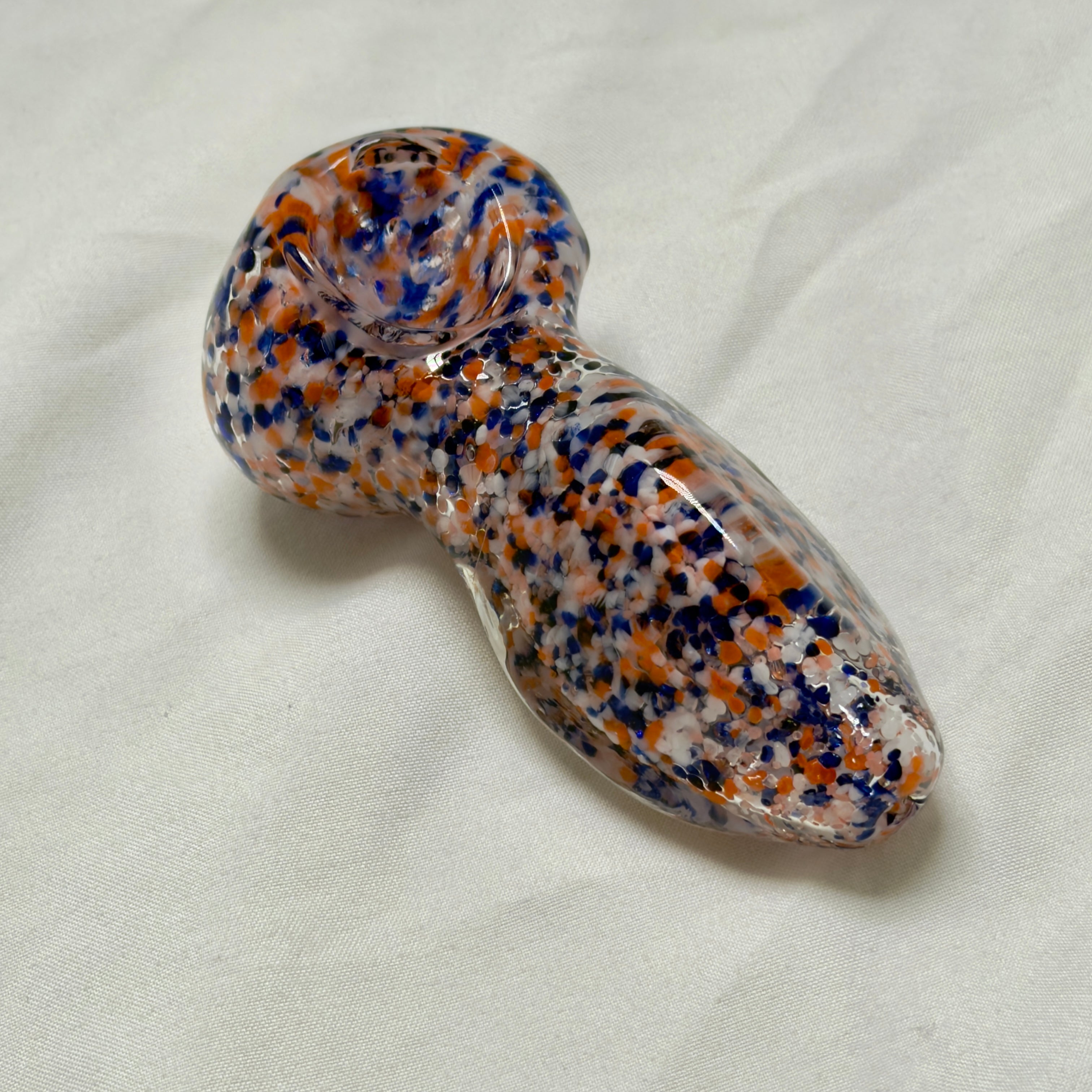 Glass pipe with multicolored speckled pattern on a white background