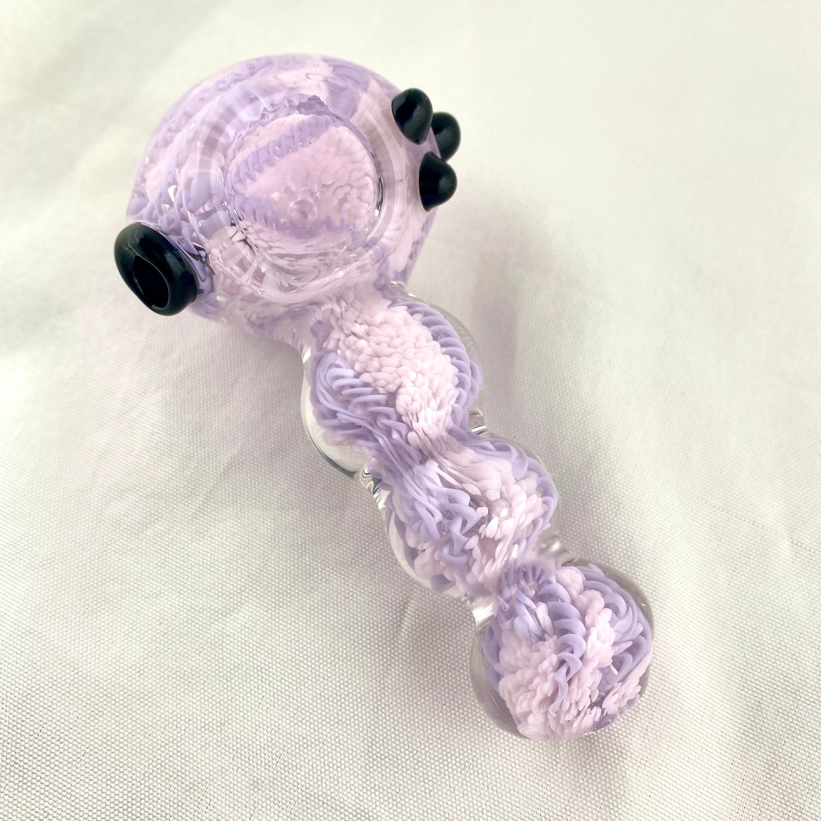 Glass pipe with purple and white swirl design on a light gray background