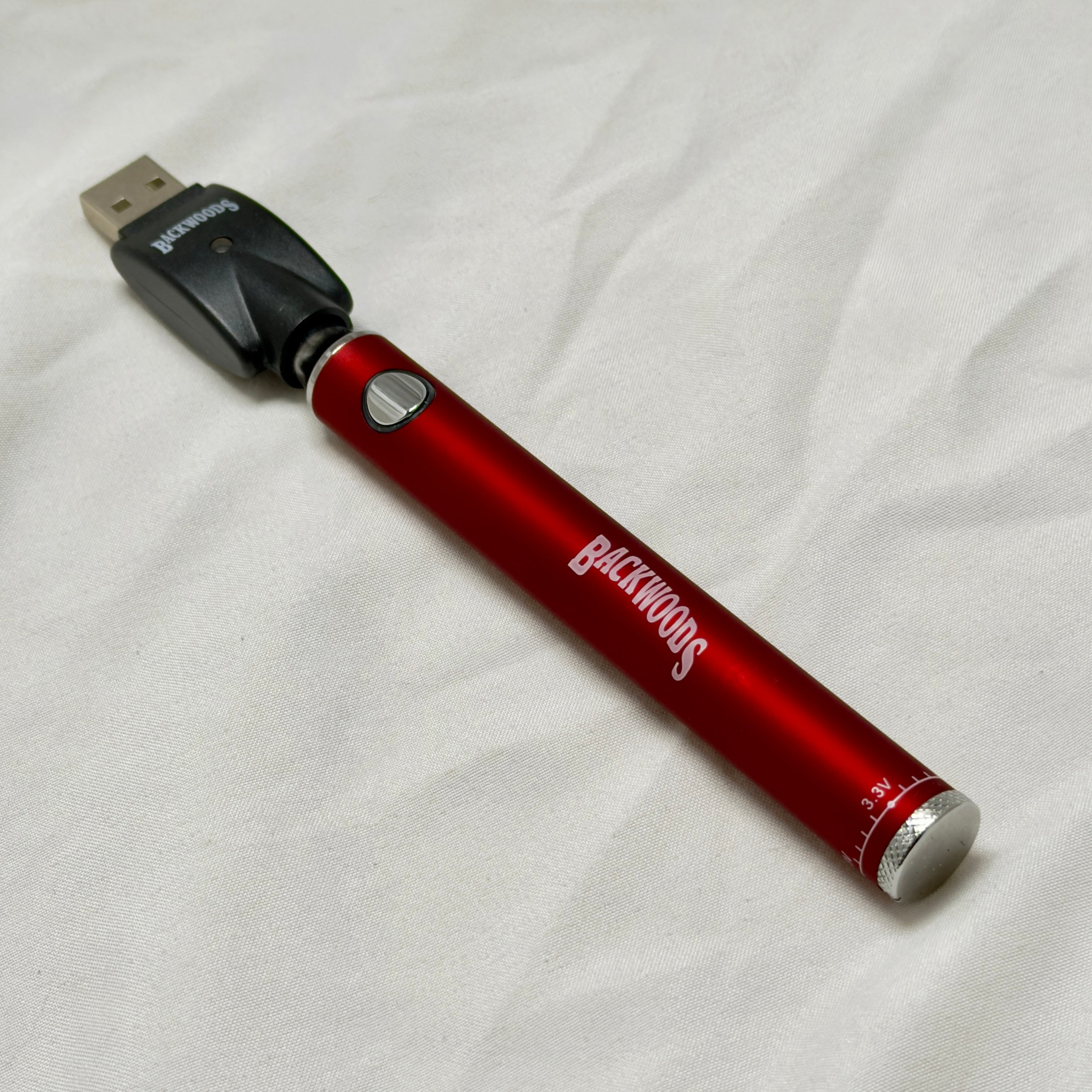 Red electronic device with 'Blackwoods' branding on a white fabric background