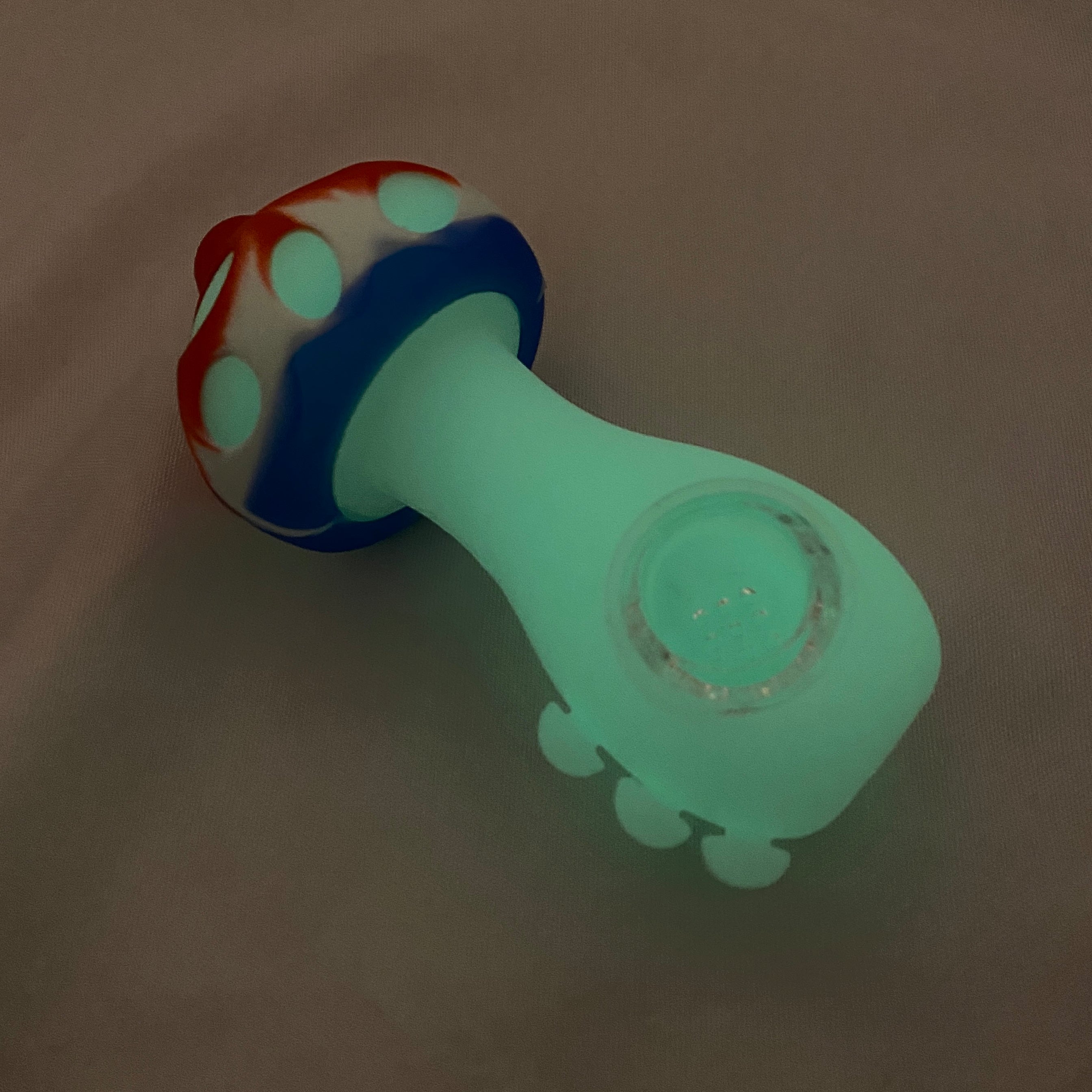 Colorful toy with a blue handle and red and white top on a beige background