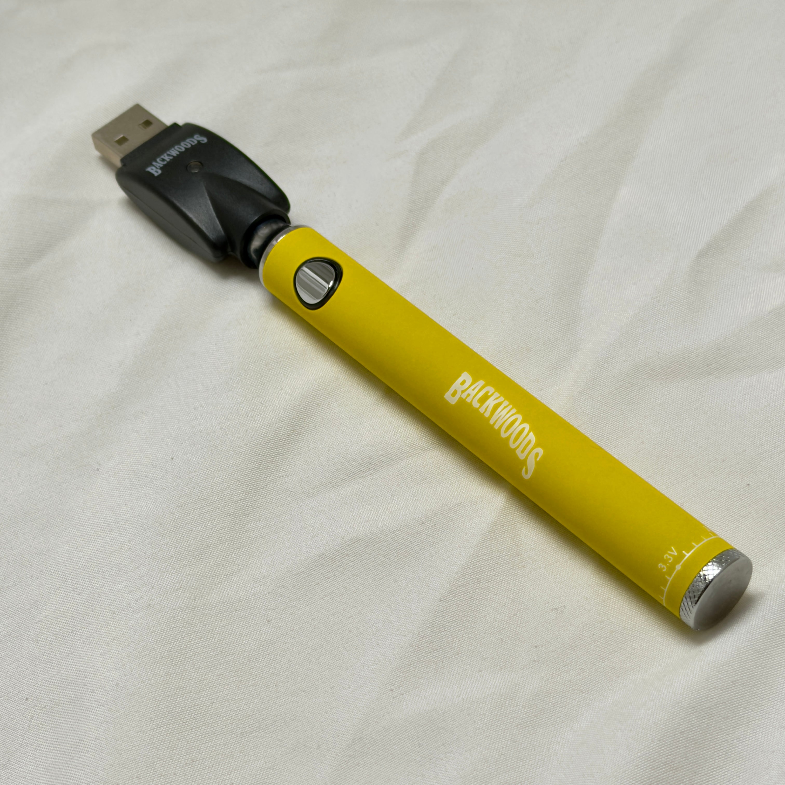 Yellow vape pen with USB connector on a white fabric background